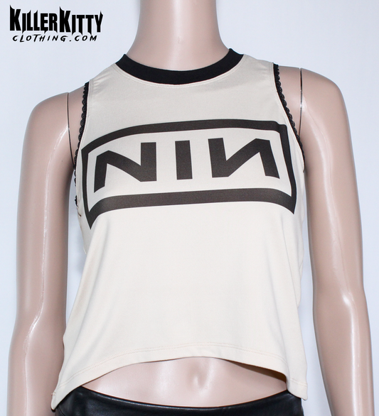 Nine Inch Nails Tank Top – Relaxed Fit Shirt Vintage tan with a black crew neck and black lace-edged trim at the arms. Customizable hem and length. Mannequin wearing a beige tank top with 'NIN' logo on a white background, branded 'Killer Kitty Clothing'.