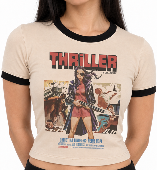 A woman wearing a beige ringer t-shirt with black trim and a large graphic print of the movie 'Thriller'. Tan ringer t-shirt with black trim at neck and sleeves, featuring vintage poster artwork from the 1973 Cult Classic Exploitation film Thriller: A Cruel Picture. Double brushed knit, three lengths.