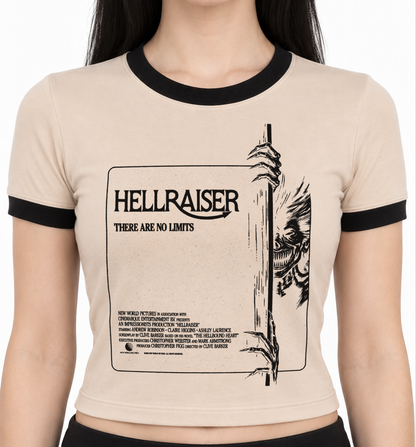 A tan ringer t-shirt with black trim on the crew neck and sleeves, featuring a black graphic print of the movie 'Hellraiser' on the front, modeled on a person against a white background. Women's Hellraiser ringer t shirt. 80s horror cult classic hellraiser. women's pinhead shirt. spooky horror shirts for women. 80s horror shirts for women. women's ladies vintage pinhead hellraiser shirt. alternative 90s clothes for women. killer kitty clothing horror tees for women. angel to some demon to others shirt. 