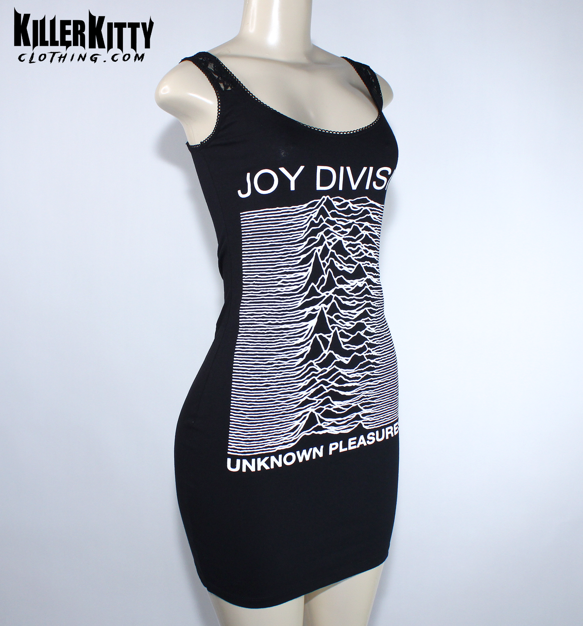A black sleeveless bodycon dress displayed on a mannequin. The dress features the white 'Joy Division' band name and their 'Unknown Pleasures' album cover graphic printed on the front. Joy Division unknown pleasures shirt. joy division unknown pleasure dress. alternative band merch for women. Joy Division lace dress. post punk dresses for women. Ian Curtis dress for women. handmade alternative fashion killer kitty clothing. diy upcycled unique band dresses. joy division bodycon dress.