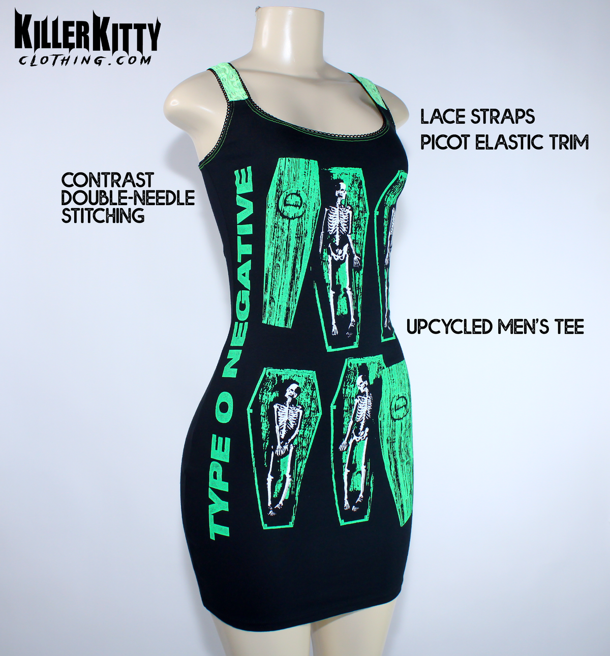 A sleeveless black mini dress with bright green trim and a graphic print of skeleton figures inside coffin shapes, displayed on a  mannequin. Type O negative dress for women. goth metal bodycon dress. peter steele goth metal dress. women's type o negative shirt. upcycled type o negative dress. heavy metal type o negative bodycon dress. diy alternative type o negative dress. killer kitty clothing upcycled band dresses. goth horror skeleton dress for women. alt fashion brand killer kitty. band dress for women